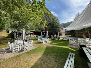 a group of white chairs and tables with umbrellas at Valldal Fjord Lodge B&B in Valldal +75 photos