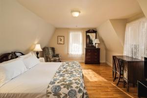 Schlafzimmer mit einem Bett, einem Schreibtisch und einem Fenster in der Unterkunft Hillcrest Hall Country Inn in Port Hood