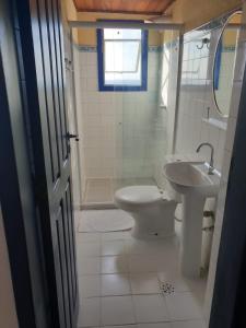 a bathroom with a toilet, sink, and tub at Pousada Beija Flor in Salvador
