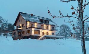a large house with lights on in the snow at Haus Stadler - Self Check-in in Tauplitz