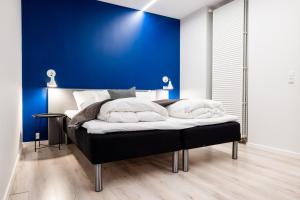 een bed in een kamer met een blauwe muur bij Hotel Sønderborg Kaserne in Sønderborg