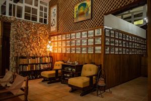 uma biblioteca com duas cadeiras, uma mesa e livros em Exclusive Hotel Don Ernesto By La Chimba em San José