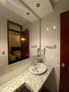 a bathroom with a sink and a mirror at Hotel Casa Bethel in Santa Marta