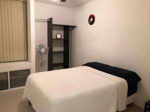 ein Schlafzimmer mit einem Bett und einer Uhr an der Wand in der Unterkunft Casa en Oasis en Xochitepec in Chiconcuac