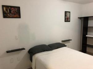 ein Schlafzimmer mit einem Bett und zwei Bildern an der Wand in der Unterkunft Casa en Oasis en Xochitepec in Chiconcuac