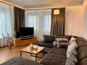 sala de estar con sofá y TV en Ferienhaus Mang, en Blaichach