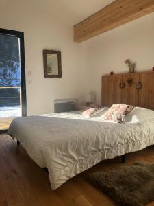 ein großes Bett in einem Schlafzimmer mit einem großen Fenster in der Unterkunft Villa Marcassin in Boulc