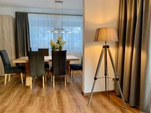 a dining room with a table and chairs and a lamp at Ferienhaus Mang in Blaichach