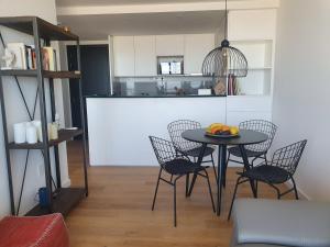 comedor con mesa y sillas y cocina en Modern apartment first line beach Montevideo UY, en Montevideo