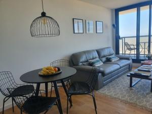 sala de estar con sofá y mesa con fruta. en Modern apartment first line beach Montevideo UY, en Montevideo