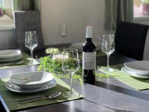 a table with a bottle of wine and two wine glasses at Apart Kathrin in Fliess