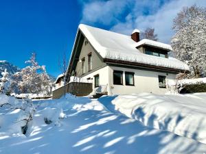 a house covered in snow with a pile of snow at Ferienhaus Mang in Blaichach