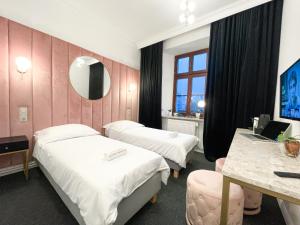 pokój hotelowy z dwoma łóżkami i lustrem w obiekcie Apartamenty Stary Browar Oleśnica w mieście Oleśnica