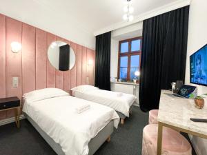 pokój hotelowy z dwoma łóżkami i lustrem w obiekcie Apartamenty Stary Browar Oleśnica w mieście Oleśnica