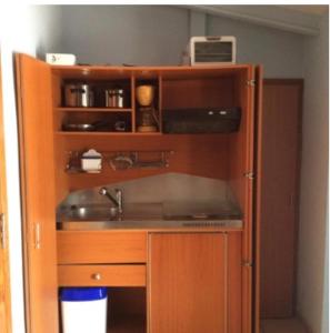 a kitchen with a wooden cabinet with a sink at Apartamento Centrico con Terraza in Platja  d'Aro