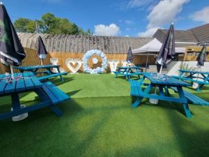 a group of blue picnic tables on the grass at The Swan Inn in Stranraer