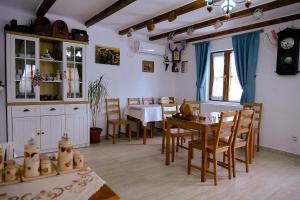 een keuken en eetkamer met een tafel en stoelen bij Dumbrava in Uzlina