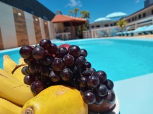 a bunch of fruit on a table near a pool at Pousada Caminho do Mar in Torres