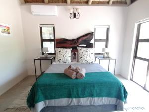 1 dormitorio con 1 cama con 2 toallas en Amukela Kaya en Hoedspruit