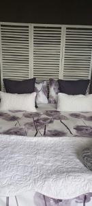 a large bed with white sheets and pillows at V's studio in Ballito