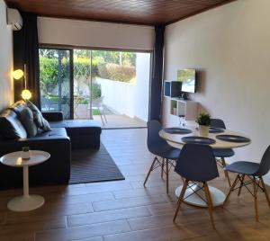 a living room with two tables and a couch at Vilamoura Garden House - Golf & Beach in Vilamoura