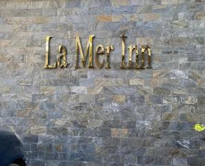 科澤科德的住宿－La Mer Inn，砖墙上的一个标牌,上面写着毛线