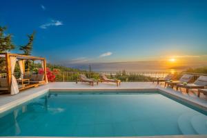 a swimming pool with a view of the sunset at Luxury Villa Fiscardo Walk - Heated Pool & Jacuzzi in Fiskardo