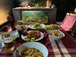 a table with plates of food and a fishtank at Mallis Guesthouse in Habaraduwa