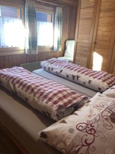 2 camas en una habitación con ventanas en Distel, en Ritzingen