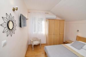 sypialnia z łóżkiem, lustrem i krzesłem w obiekcie Apartment Stella w Dubrowniku