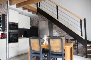 a kitchen with a table with chairs and a staircase at Cottage Le Phare - Le Clos de la Morière in Mont-Dol