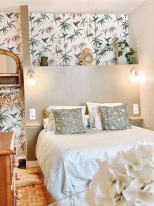 a bedroom with a large bed with a tropical wallpaper at Puerta al cielo Suite in Burgos