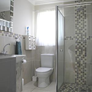 a bathroom with a toilet and a glass shower at Allalapstix in Reebok