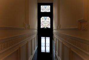 a hallway with a stained glass window in a building at Apartment in trendy Chatelain center Brussels area Little Garden Internet wifi in Brussels
