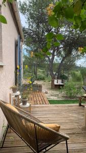 una sedia seduta su una terrazza di legno di Villa en bordure de colline*piscine*clim*netflix a Les Matelles Altre 20 foto