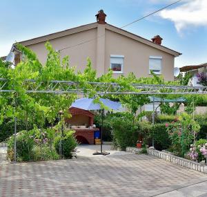a garden in front of a house at Apartmani Danijela Lopar in Lopar