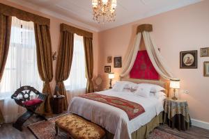 a bedroom with a large bed and a chandelier at La Maison Ottomane in Chania