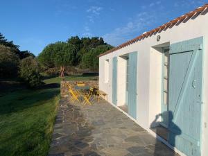 a patio with a table and chairs next to a building at Maison 100 m plage, 2 kms du port in L'Ile d'Yeu