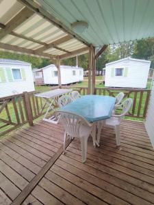 a patio with a table and chairs on a deck at Mobil-Home Cosy 5 personnes camping le Ried - Europapark in Boofzheim