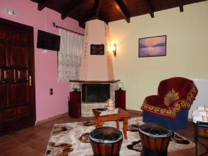 a living room with a fireplace and a chair at Junior Suite Selini for 2 people in Vitina