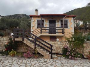 a house with a staircase in front of a building at Junior Suite Selini for 2 people in Vitina