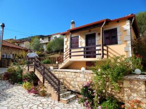 uma casa com uma escada em frente a uma parede de pedra em Junior Suite Selini for 2 people em Vytina