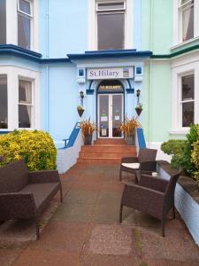a blue building with chairs in front of it at St. Hilary Guest House in Llandudno