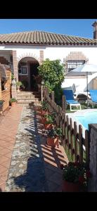 a house with a fence and potted plants next to a pool at FINCA LOS CHATOS in Cádiz