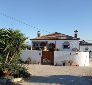 una casa blanca con una puerta y una valla en FINCA LOS CHATOS en Cádiz