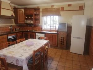 a kitchen with a table and a white refrigerator at FINCA LOS CHATOS in Cádiz