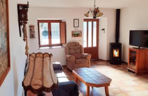 a living room with a couch and a chair and a tv at Stone Cottage O CEBREIRO in Curtis