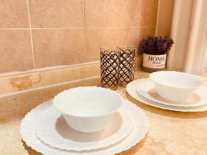 two white bowls and plates on a counter at الأراضي السبع in Yanbu