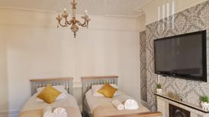 a living room with two beds and a flat screen tv at Fairoak Lodge in Newport