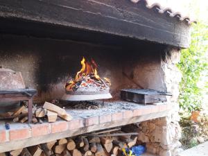 een bakstenen oven met een vuur erin bij Apartments Krizmanić in Ždrelac